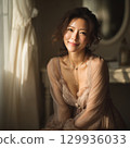 A stylish, beautiful Japanese woman relaxing by the window (square photo) 129936033