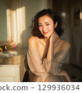 A stylish, beautiful Japanese woman relaxing by the window (square photo) 129936034