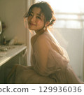A stylish, beautiful Japanese woman relaxing by the window (square photo) 129936036