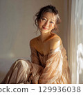 A stylish, beautiful Japanese woman relaxing by the window (square photo) 129936038