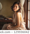 A stylish, beautiful Japanese woman relaxing by the window (square photo) 129936042