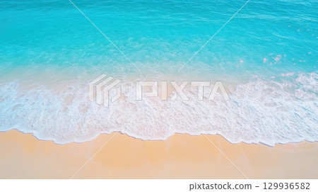 serene beach with crystal clear waves gently lapping at shore, creating peaceful atmosphere 129936582