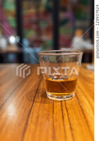 木質桌面上的一杯琥珀色飲料 129937624