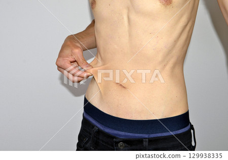 赤裸上身的男人摀著身體一側 129938335