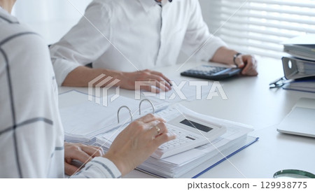 Close up of a calculator on financial documents, with an accountant hands working with, finance, and tax preparation. Audit and taxes in business Close up of a calculator on financial documents, with an accountant hands working with, finance, and tax preparation. Audit and taxes in business 129938775