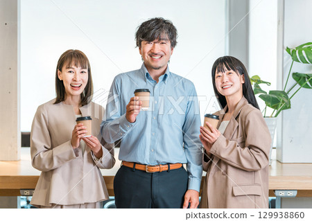 Businessman and businesswoman chatting over coffee in the office Businessman and businesswoman chatting over coffee in the office 129938860