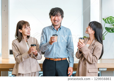 Businessman and businesswoman chatting over coffee in the office Businessman and businesswoman chatting over coffee in the office 129938861