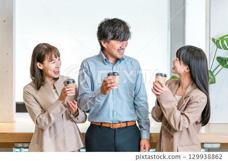 Businessman and businesswoman chatting over coffee in the office 129938862