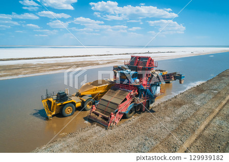 Heavy machinery works along the banks of Baskunchak Lake, actively extracting salt and transporting it into large trucks. Heavy machinery works along the banks of Baskunchak Lake, actively extracting salt and transporting it into large trucks. 129939182