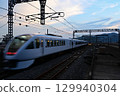 Spacia X12 departs Tochigi Station at dusk and accelerates. 129940304