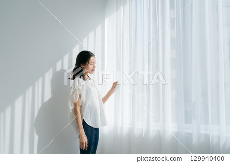 一個女人站在窗邊 一個女人站在窗邊 129940400