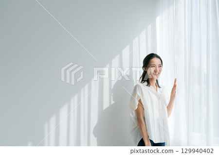 A woman standing by the window A woman standing by the window 129940402