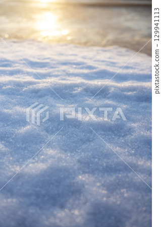 冰凍的水坑在清晨的陽光下閃閃發光 129941113