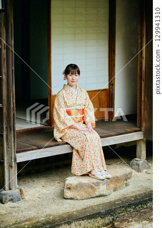一位身著和服的女子靜靜地站在陽台上 129941310