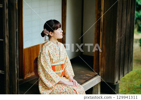 一位身著和服的女子靜靜地站在陽台上 129941311