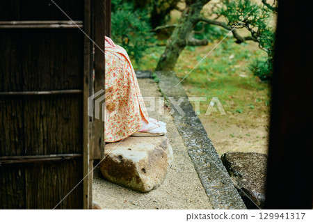 一位身著和服的女子靜靜地站在陽台上 129941317