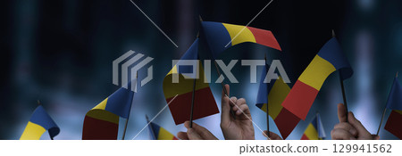 Romania flags in their hands on a blurred urban background 129941562