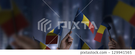 Romania flags in their hands on a blurred urban background 129941565