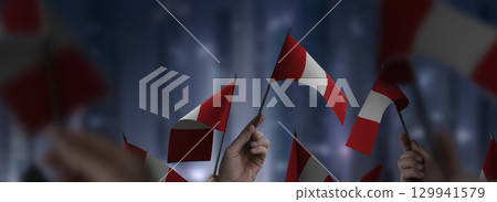 Peru flags in their hands on a blurred urban background 129941579