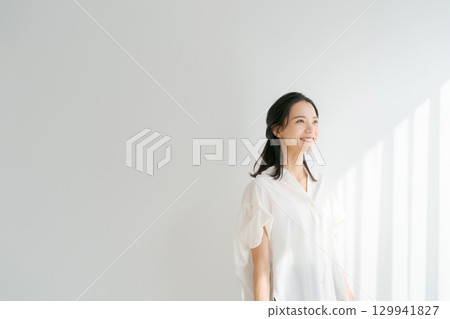 一位女士在窗邊沐浴陽光 一位女士在窗邊沐浴陽光 129941827