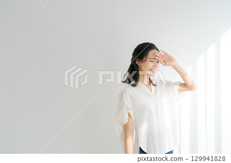 一位女士在窗邊沐浴陽光 一位女士在窗邊沐浴陽光 129941828