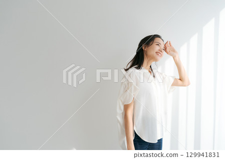一位女士在窗邊沐浴陽光 一位女士在窗邊沐浴陽光 129941831