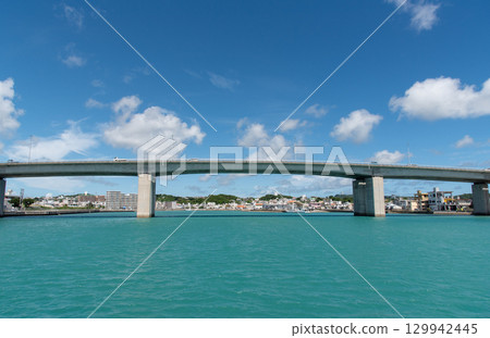一座橫跨翠綠大海的橋和一座海濱小鎮 129942445