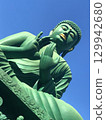 The Great Buddha's gold-glowing mouth stands out against the blue sky 129942680
