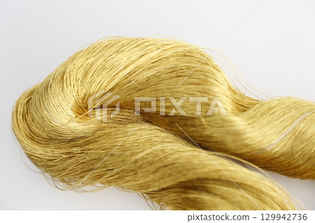 白色背景下拍攝的金線和略帶紅色的金線 129942736