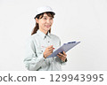A young Asian woman in work clothes holding a board 129943995