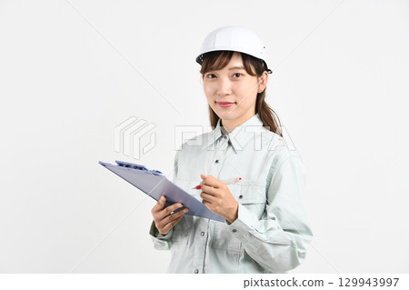 A young Asian woman in work clothes holding a board 129943997