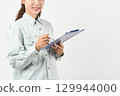 A young Asian woman in work clothes holding a board 129944000