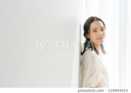站在窗邊的穿襯衫的女人 站在窗邊的穿襯衫的女人 129944424