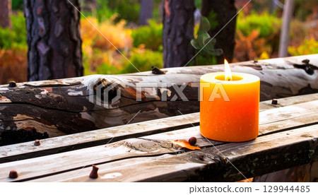 Reclaimed Wood Surface with a Burning Beeswax Candle 129944485