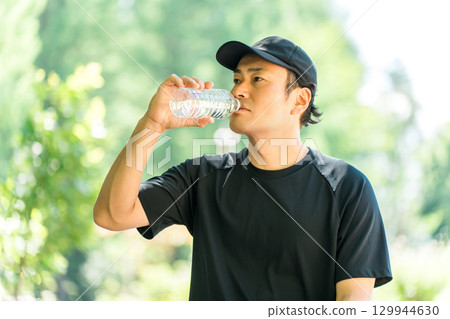 男性在運動時喝水/礦泉水(補水、運動、運動、跑步、步行) 男性在運動時喝水/礦泉水(補水、運動、運動、跑步、步行) 129944630
