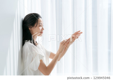 窗邊按摩雙手的女人 窗邊按摩雙手的女人 129945046
