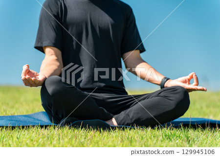 一個男人在公園裡做瑜珈/皮拉提斯(運動/冥想/運動/瑜珈/運動/伸展) 一個男人在公園裡做瑜珈/皮拉提斯(運動/冥想/運動/瑜珈/運動/伸展) 129945106