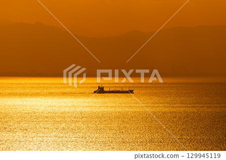 A cargo ship floating in Ise Bay at sunset 129945119