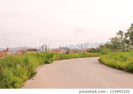rural road in vietnam with people riding bicycles and motorbikes rural road in vietnam with people riding bicycles and motorbikes 129945282