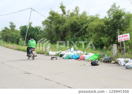 rural road in vietnam with people riding bicycles and motorbikes rural road in vietnam with people riding bicycles and motorbikes 129945308