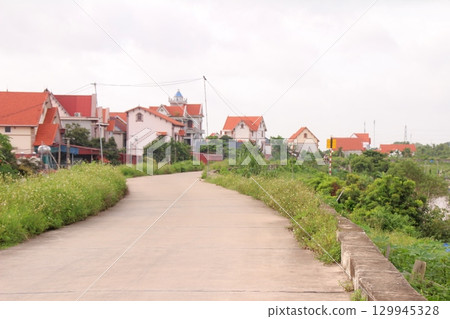 rural road in vietnam with people riding bicycles and motorbikes 129945328