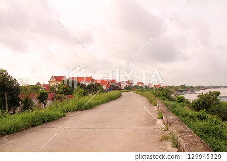 rural road in vietnam with people riding bicycles and motorbikes 129945329