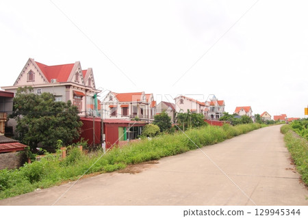 rural road in vietnam with people riding bicycles and motorbikes 129945344