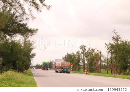 rural road in vietnam with people riding bicycles and motorbikes rural road in vietnam with people riding bicycles and motorbikes 129945352