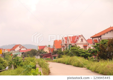 rural road in vietnam with people riding bicycles and motorbikes 129945445