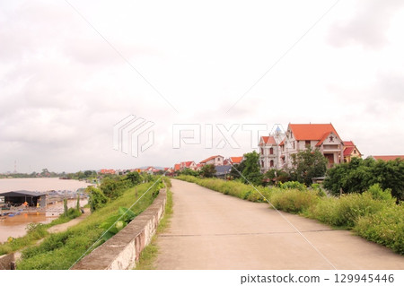rural road in vietnam with people riding bicycles and motorbikes 129945446