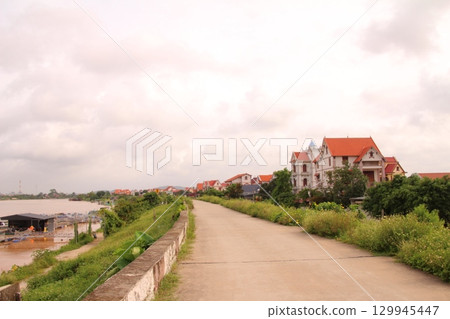 rural road in vietnam with people riding bicycles and motorbikes 129945447