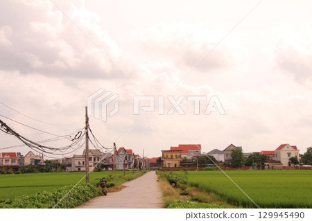 rural road in vietnam with people riding bicycles and motorbikes 129945490