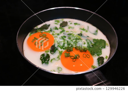 fried egg or sunny side up egg with vegetable topping in a pan fried egg or sunny side up egg with vegetable topping in a pan 129946226