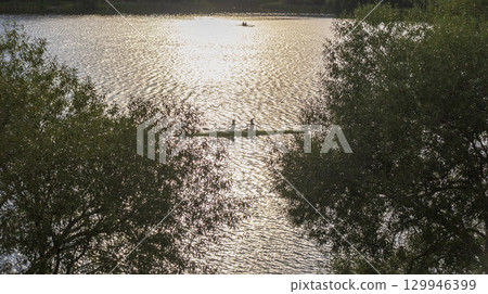 People practicing rowing on the lake. Sports People practicing rowing on the lake. Sports 129946399